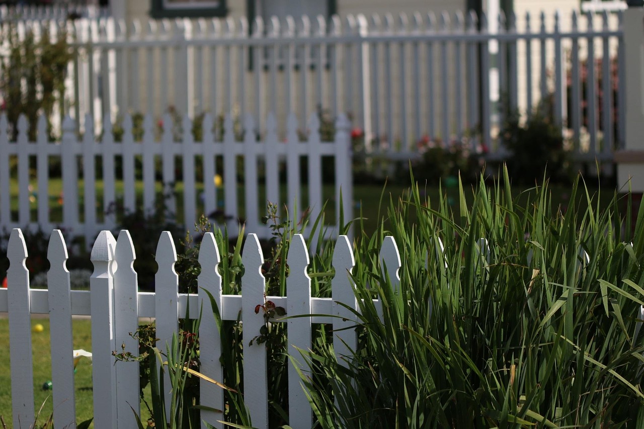 White picket fence running along a residential front yard